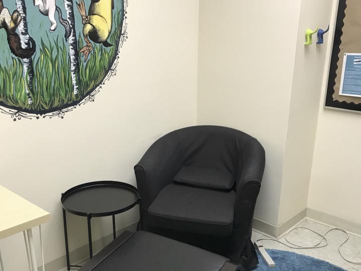 chair with small table power strip and wall mural 